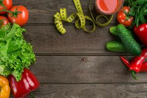 vidro do tomate suco com legumes e medindo fita em mesa fechar-se foto