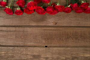 vermelho rosas ramalhete sobre de madeira mesa. topo Visão com cópia de espaço. flores foto