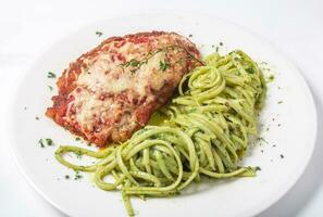 frango com parmesão queijo e Macarrão espaguete achatado massa dentro pesto molho foto