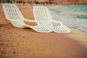 panorama do dois solitário cadeiras de praia perto a mar foto