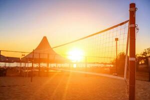 Sillhouette do uma voleibol internet e nascer do sol em a de praia foto