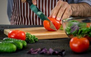 masculino mãos corte legumes para salada foto