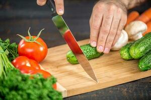 masculino mãos corte legumes para salada foto