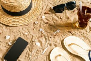 verão roupa de praia, giro fracassos, chapéu, oculos de sol e conchas do mar em areia de praia. foto