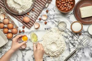 fechar-se tomada. topo Visão do uma padeiro cozinhar lugar, mãos estão trabalhando com uma cru massa em a mármore mesa fundo. foto