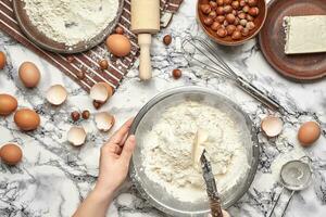 fechar-se tomada. topo Visão do uma padeiro cozinhar lugar, mãos estão trabalhando com uma cru massa em a mármore mesa fundo. foto