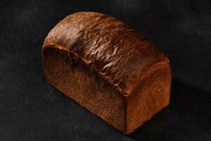 todo pão do fresco, delicioso cozido Sombrio pão contra Preto fundo com cópia de espaço. fechar-se foto