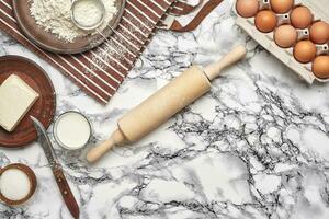 fechar-se tomada. topo Visão do uma cozimento ingredientes e utensílios de cozinha em a mármore mesa fundo. foto