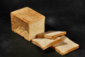 fatiado pão do fresco, saboroso cozido branco pão contra Preto fundo com cópia de espaço. fechar-se foto