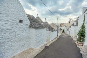 lindo Cidade do alberobello com trulli casas entre verde plantas e flores, Puglia região, sulista Itália. foto