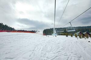 esqui lift às esqui recorrer Bukovel dentro a montanhas em uma ensolarado inverno dia. foto