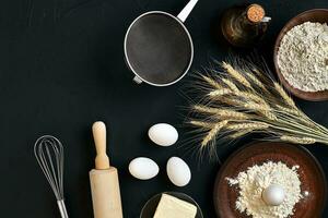 massa cozinhando ingredientes em Preto cozinha mesa. topo Visão com espaço para seu texto foto