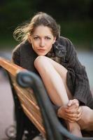 bela jovem sentada em um banco foto