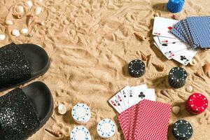 poker de praia. salgadinhos e cartões em a areia. por aí a conchas do mar e giro fracassos. topo Visão foto