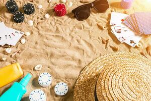 poker de praia. salgadinhos e cartões em a areia. por aí a conchas, oculos de sol e chapéu. topo Visão foto