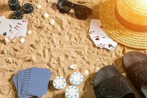 poker de praia. salgadinhos e cartões em a areia. por aí a conchas, oculos de sol e giro fracassos. topo Visão foto