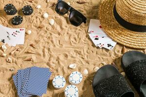 poker de praia. salgadinhos e cartões em a areia. por aí a conchas, oculos de sol e giro fracassos. topo Visão foto