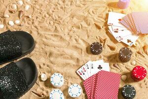 poker de praia. salgadinhos e cartões em a areia. por aí a conchas do mar e giro fracassos. topo Visão foto