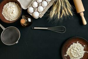 massa cozinhando ingredientes em Preto cozinha mesa. topo Visão com espaço para seu texto foto