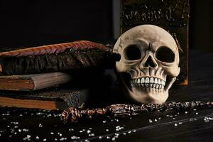 realista modelo do uma humano crânio com dentes em uma de madeira Sombrio mesa, Preto fundo. médico Ciência ou dia das Bruxas Horror conceito. fechar-se tomada. foto