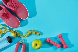 tênis com medindo fita em ciano azul fundo. esporte sapatos e esportivo equipamento para saudável forma. foto