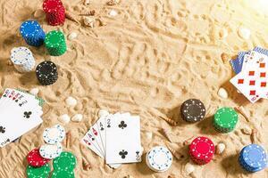 poker de praia. salgadinhos e cartões em a areia com conchas. topo Visão foto