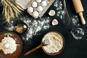 massa cozinhando ingredientes em Preto cozinha mesa. topo Visão com espaço para seu texto foto