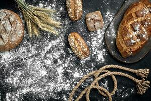 diferente pão com farinha e espiguetas do Wheaton Preto fundo foto