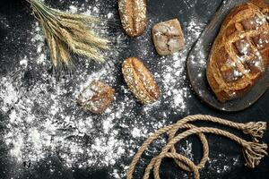 diferente pão com farinha e espiguetas do Wheaton Preto fundo foto