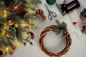 fêmea mãos decorar a Natal guirlanda com abeto galhos com uma vermelho baga e floresta cones. branco fundo. Novo anos conceito. foto