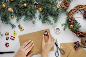 fêmea mãos aguarde alegre Natal cartão e envelope. Natal decoração fundo. plano deitar, topo visualizar. foto