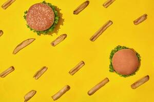 Projeto conceito do brincar hambúrgueres e francês fritas conjunto em amarelo fundo. foto