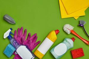 detergentes e limpeza acessórios em uma verde fundo. serviço de limpeza conceito. foto