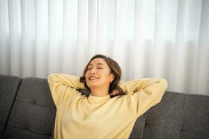 mulher estilo de vida relaxante dormindo em sofá vivo quarto e sorridente, acordando acima dentro a manhã e sonolento durante a dia foto