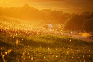 carro viajando em uma estrada rural entre campos foto