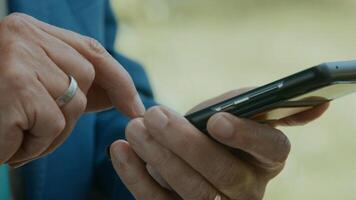 mãos do homem na área verde digitando no smartphone foto