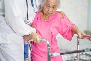 cuidados médicos asiáticos, ajuda e apoio paciente idoso caminhar com andador foto