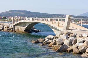 ponte de pedra para conectar uma ilhota no estuário do arosa foto