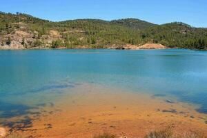 a lago é cercado de montanhas e árvores foto