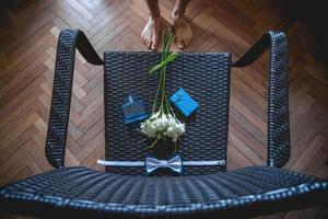 buquê de casamento, lenço borboleta e caixa de presente na cadeira foto