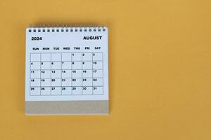 agosto 2024 escrivaninha calendário em amarelo fundo. diretamente acima. plano deitar. foto