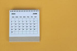 Junho 2024 escrivaninha calendário em amarelo fundo. diretamente acima. plano deitar. foto