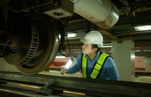 engenheiros para elétrico trens depois de detecção dificuldades com a elétrico trem maquinaria usar holofotes para localizar e Verifica estragado Seções. dentro a elétrico trem reparar fazer compras foto