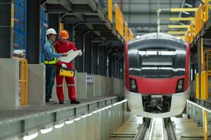 depois de a elétrico trem é estacionado dentro a elétrico trem reparar comprar, elétrico trem engenheiro e técnico com Ferramentas inspecionar a estrada de ferro e elétrico trens dentro conformidade com a inspeção volta foto