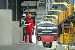 depois de a elétrico trem é estacionado dentro a elétrico trem reparar comprar, elétrico trem engenheiro e técnico com Ferramentas inspecionar a estrada de ferro e elétrico trens dentro conformidade com a inspeção volta foto