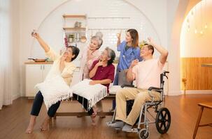 grupo do ásia Senior e cuidador tendo Diversão com selfie dentro a enfermagem lar. foto