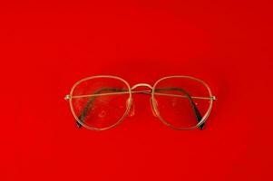 uma par do óculos em uma vermelho fundo foto