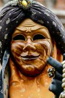 uma carnaval mascarar com uma Preto e ouro cabeça cobertura foto