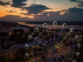 lindo pôr do sol sobre a cidade com uma iluminado ferris roda. foto