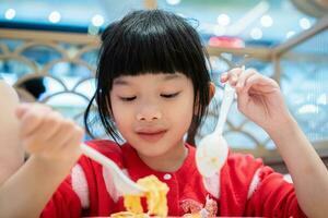 fofa pequeno ásia criança menina comendo Comida foto